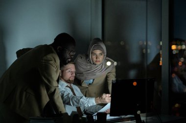 Kültürler arası iki meslektaşına finansal verileri sunan kendine güvenen genç bir borsacı.