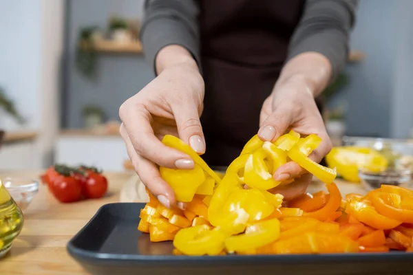 雌性手把切碎的新鲜黄色辣椒放在盘子里 — 图库照片