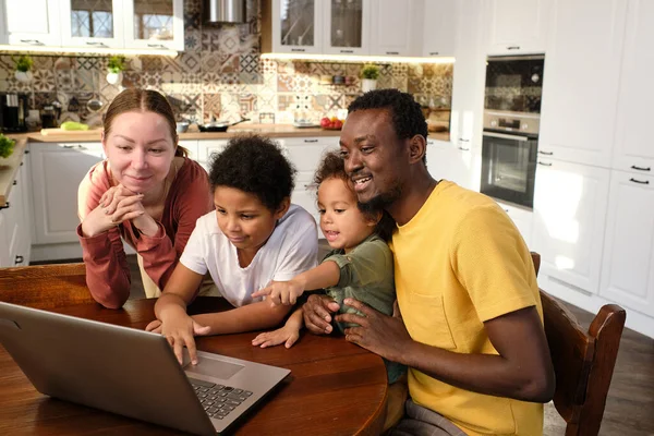 Feliz joven familia intercultural de padres y sus dos hijos pequeños —  Fotos de Stock