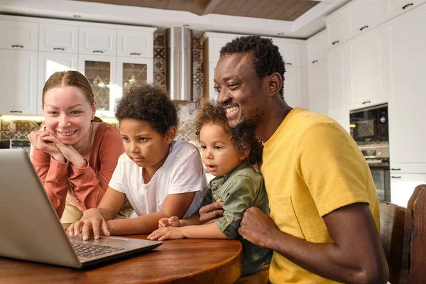 Vidám családtagok hétköznapi viseletben nézik a laptop képernyőjét — Stock Fotó