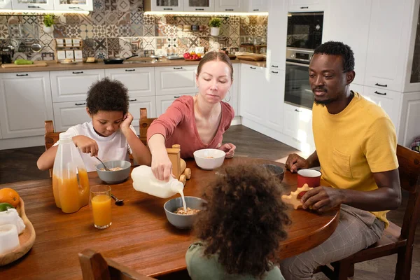 Joven familia interracial de padre, madre y dos hijos lindos desayunando —  Fotos de Stock