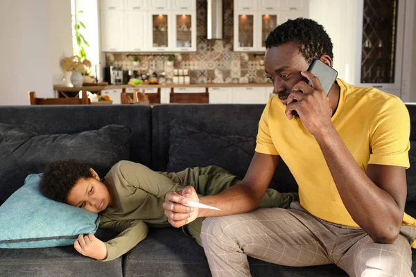 Joven hombre africano con teléfono inteligente de oído médico que llama —  Fotos de Stock