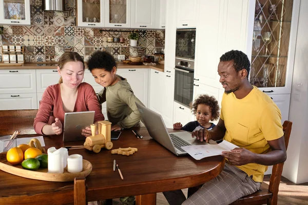 Joven familia interracial de cuatro viendo vídeo en línea —  Fotos de Stock
