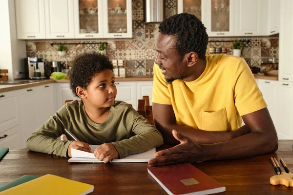 Joven hombre africano explicando algo a su hijo birracial —  Fotos de Stock