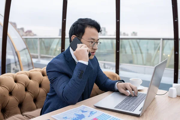 Young busy Chinese broker talking on mobile phone — Foto Stock