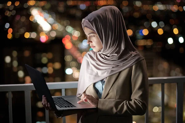 Ernstige jonge zakenvrouw met laptop op zoek naar het scherm — Stockfoto