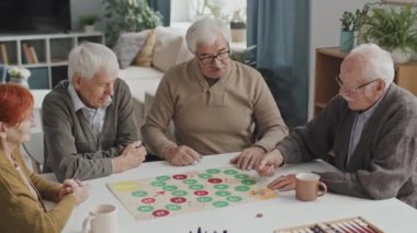 Kafkasyalı dört son sınıf öğrencisinin rahat bir huzurevinde masada otururken çekilmiş orta boy bir fotoğrafı.