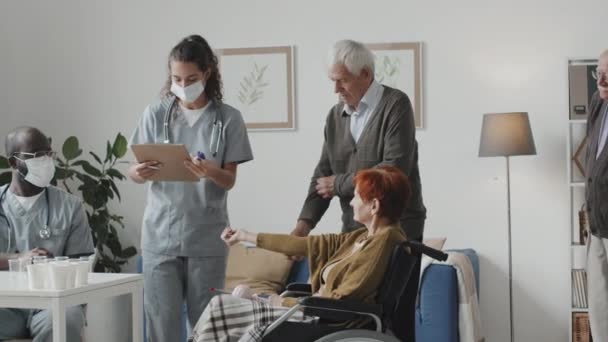 Medium Shot Two Multiethnic Medical Workers Measuring Temperatures Seniors Nursing — 图库视频影像