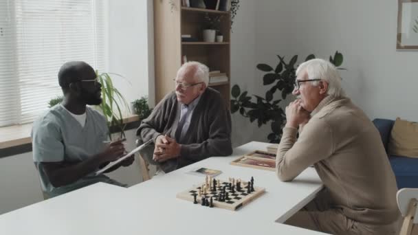 Střední Záběr Mladého Afroamerického Ošetřovatele Podložkou Mluvící Dvěma Kavkazskými Staršími — Stock video