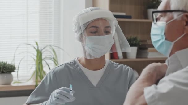Средний Снимок Белого Мужчины Маске Лица Сделанный Молодой Медсестрой Защитном — стоковое видео