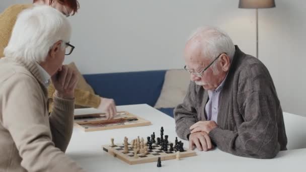 Mittlere Aufnahme Von Zwei Nachdenklichen Kaukasischen Senioren Die Schach Tisch — Stockvideo