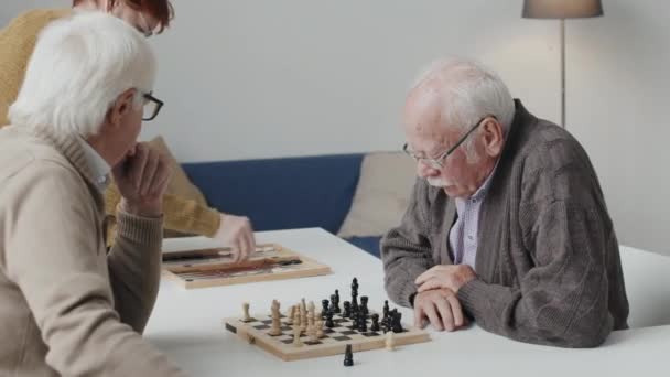 Tiro Médio Dois Homens Idosos Caucasianos Pensativos Jogando Xadrez Mesa — Vídeo de Stock