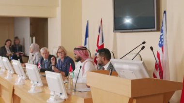 Arap ülkesinin erkek siyasetçisinin geleneksel kıyafetlerle konferans salonunun tribününde konuşma yaparken orta boy fotoğrafı.