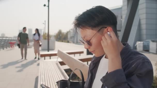 Tilt Shot Short Haired Young Asian Woman Dark Sunglasses Wireless — Vídeos de Stock