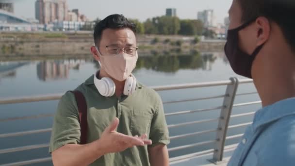 Medio Disparo Dos Jóvenes Asiáticos Máscaras Faciales Estrechando Las Manos — Vídeo de stock