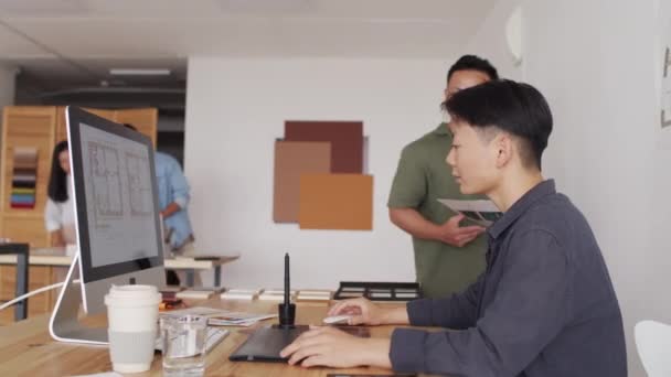 現代オフィスで新しい家の色のサンプルを選択する創造的なアジアの建築家のチームの中のショット — ストック動画