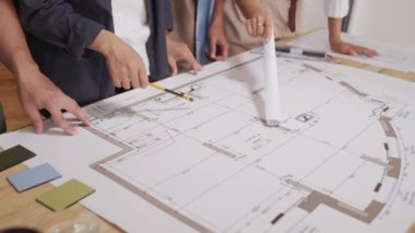 Ev planı üzerinde çalışan tanınmayan mimarlardan oluşan bir ekip ofislerindeki masalarında toplandı.