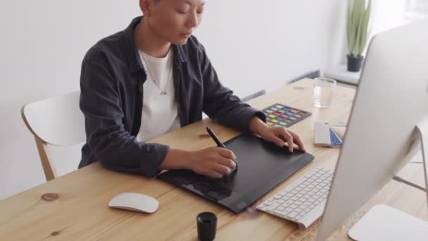 앉아서 컴퓨터 모니터를 스타일러스가 타블렛에 그려진 아시아 그래픽 디자이너의 — 비디오