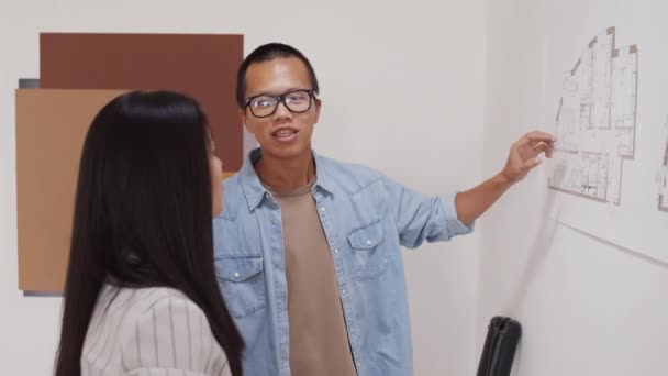 Medelhög Bild Ung Manlig Asiatisk Arkitekt Som Förklarar Detaljer Bostadsprojekt — Stockvideo