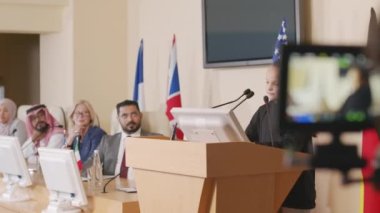 Farklı ülkelerden siyasi liderlerle yapılan basın toplantısında tribünde konuşma yapan küçük bir çevreci aktivistin orta boy çekimi.