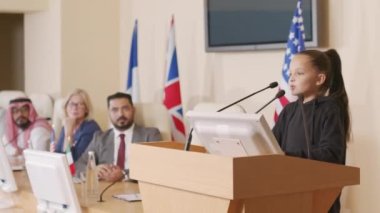 Çevre topluluğundan küçük bir kızın basın toplantısı sırasında tribünde duran iklim değişikliğinden bahsederek farklı ülkelerin siyasi liderlerine hitap ettiği orta ölçekli bir fotoğraf.