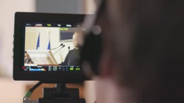 Küçük kadın çevreci aktivistin konferansta iklim değişikliği hakkında konuşmasını yaparken orta ölçekli bir video kamera görüntüsü.