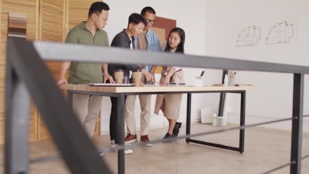 Team Professional Asian Architects Discussing Building Plan Rolled Out Desk — Stockvideo