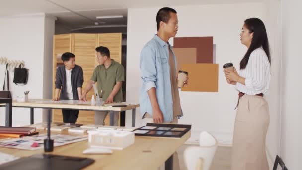 사무실에서 휴게실에서 대화하고 아시아 건축가 그들의 동료들 프로젝트를 배경으로 작업하고 — 비디오