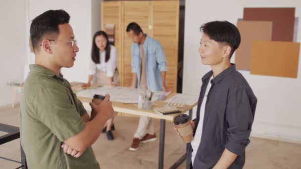 Közepes Lövés Két Ázsiai Építész Papír Kávéscsészével Kezében Miközben Beszélgetés — Stock videók