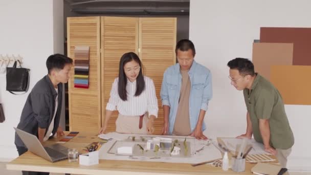 Średni Ujęcie Zespołu Czterech Azjatyckich Architektów Patrząc Plan Domu Układ — Wideo stockowe