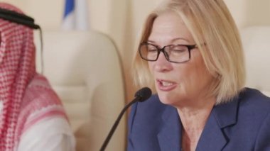 Basın toplantısında mikrofonla konuşan orta yaşlı sarışın, Kafkas siyasi liderin yakın plan fotoğrafı.