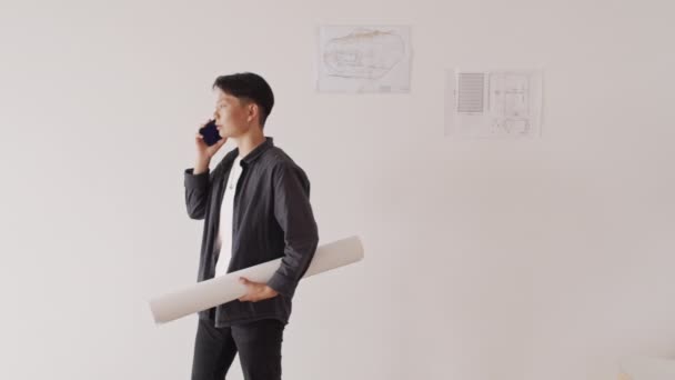 Beyaz Duvarın Önünde Duran Akıllı Telefondan Konuşan Planıyla Orta Boy — Stok video