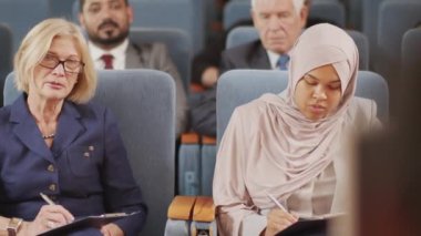 Farklı ülkelerden siyasi liderlerin konferans salonundaki siyasi forumda konuşmaları dinleyip panoya notlar alırken PAN 'ın görüntüleri