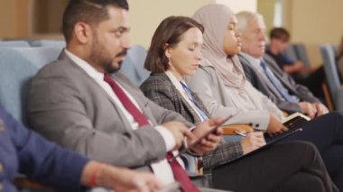 Çeşitli erkek ve kadın siyasi liderlerden oluşan PAN görüntüleri halka açık konferansta konuşma yaparken not alıyorlar