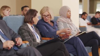 İş konferansı sırasında konferans salonunda oturan iki iş kadınının PAN çekimi