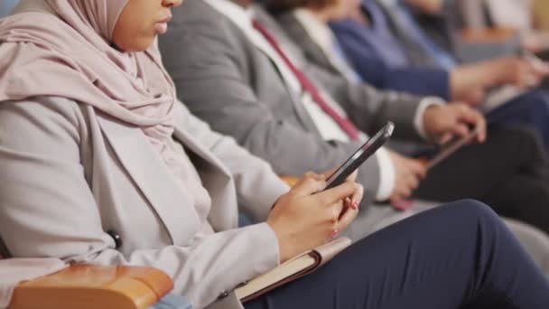 Przycięte Panoramiczne Ujęcie Młodej Muzułmanki Korzystającej Smartfona Siedzącej Audytorium Biznesmenami — Wideo stockowe