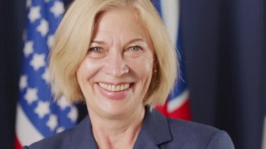 Kameraya gülümseyen Kafkas etnik kökenli orta yaşlı kadın siyasi liderin yavaş yavaş yakın portresi
