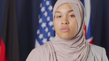 Kameraya bakan tesettürlü ciddi Müslüman kadın politikacının yavaş portresi.