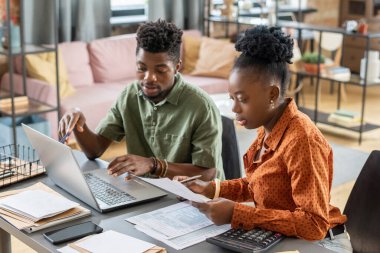 Genç ve kendinden emin işadamı, Afrikalı kadınlara evraklarıyla sunum yapıyor.
