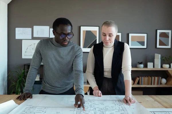 Contemporary creative architects discussing sketch on blueprint — Foto de Stock