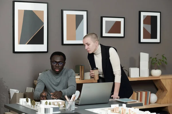 Confident African male architect presenting layout of new yard to colleague — 스톡 사진