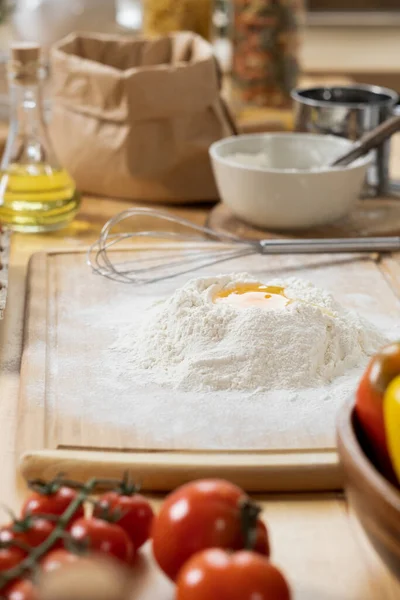 Pile of flour with broken raw egg on wooden board — Stock Photo, Image