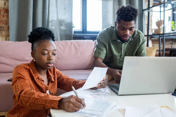 Dos jóvenes colegas africanos que trabajan con documentos financieros y datos informáticos — Foto de Stock