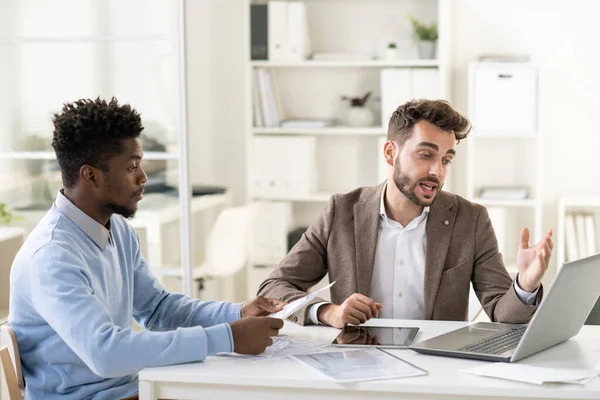 Confident businessman making presentation of online data to African colleague — Stock Photo, Image