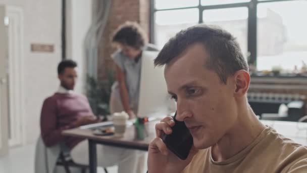 직장에서 분주하게 일하는 감독의 어깨를 핸드폰으로 이야기하는 — 비디오