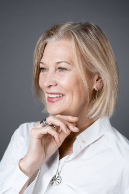 Olgun kadın kameraya poz veriyor.