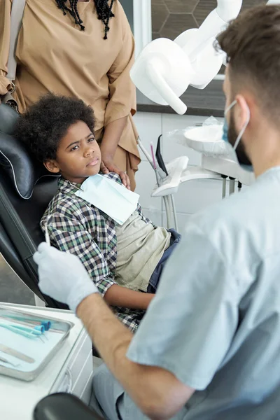 Bonito menino olhando para o dentista com gancho e espelho — Fotografia de Stock