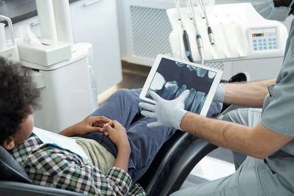 Рукавички стоматолога збільшення рентгенівського випромінювання зубів людини на екрані планшета — стокове фото