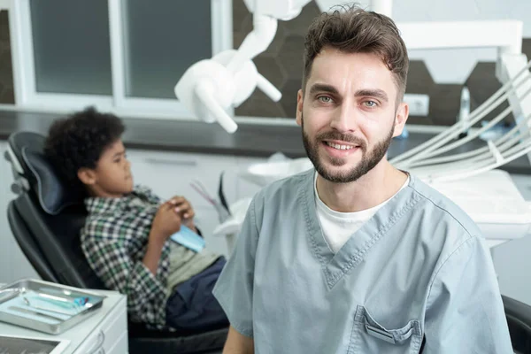 Young successful dentist in uniform looking at camera — Stock Photo, Image