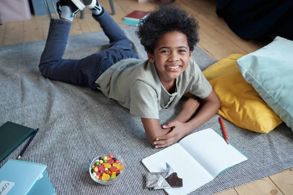 Gelukkig Afrikaans jongen kijken naar u met tanden glimlach terwijl genieten van vrije tijd — Stockfoto